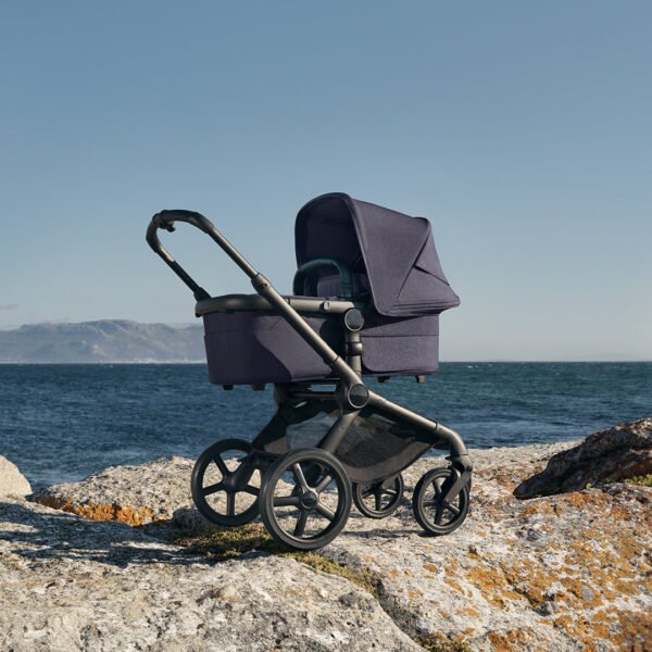 Bugaboo Fox 5 Renew tamsiai mėlynas kūdikių vežimėlis su lopšiu prie jūros ant uolų