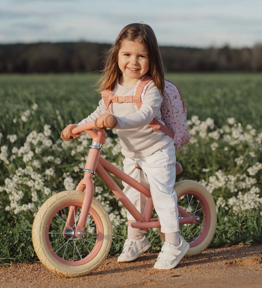 Little Dutch rozā balansa velosipēds ar gaišām riepām un bērnu mugursomu