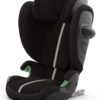 Cybex melns autokrēsliņš ar augstu atzveltni, galvas balstu un zaļiem ieliktņiem; ISOFIX stiprinājums
