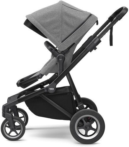 Thule Sleek bērnu ratiņi ar pelēku kulbu un melnu rāmi, redzams arī apakšējais grozs
