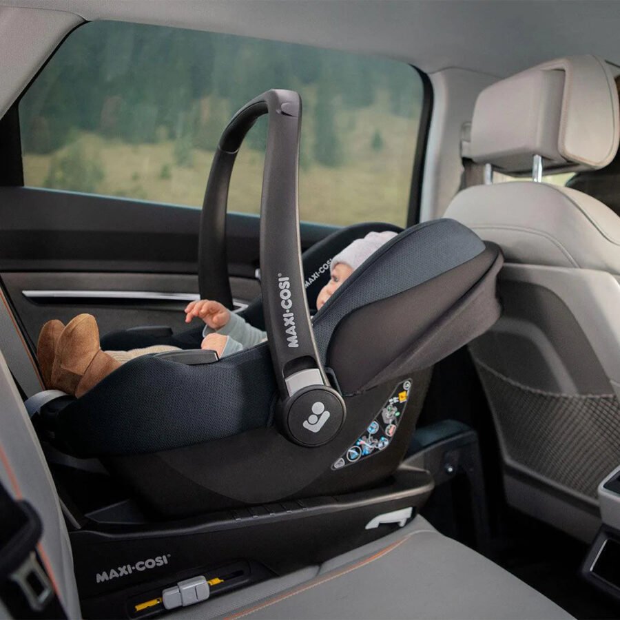 Melns Maxi-Cosi autokrēsliņš ar zīdaini, uzstādīts uz bāzes automašīnā