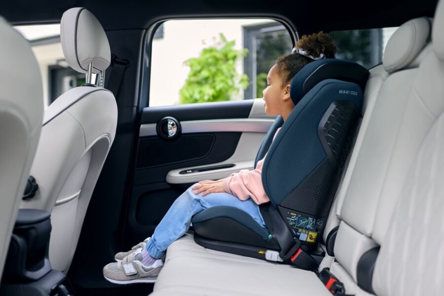 Tumši zils bērnu autokrēsliņš ar bērnu automobilī